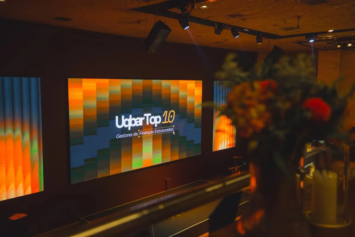 Telão com a marca Uqbar Top 10 no salão